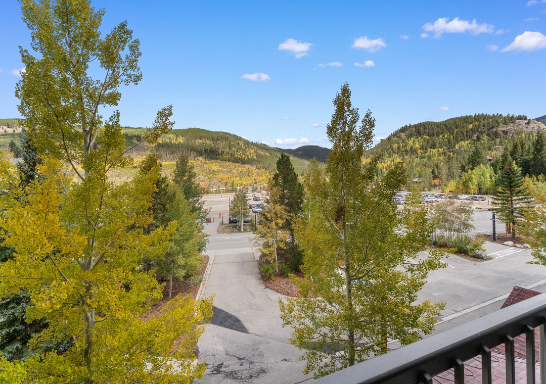 Stunning mountain views framed by golden aspens and evergreens create a picturesque backdrop for this property, nestled in a scenic valley with convenient access to nearby parking and facilities.
