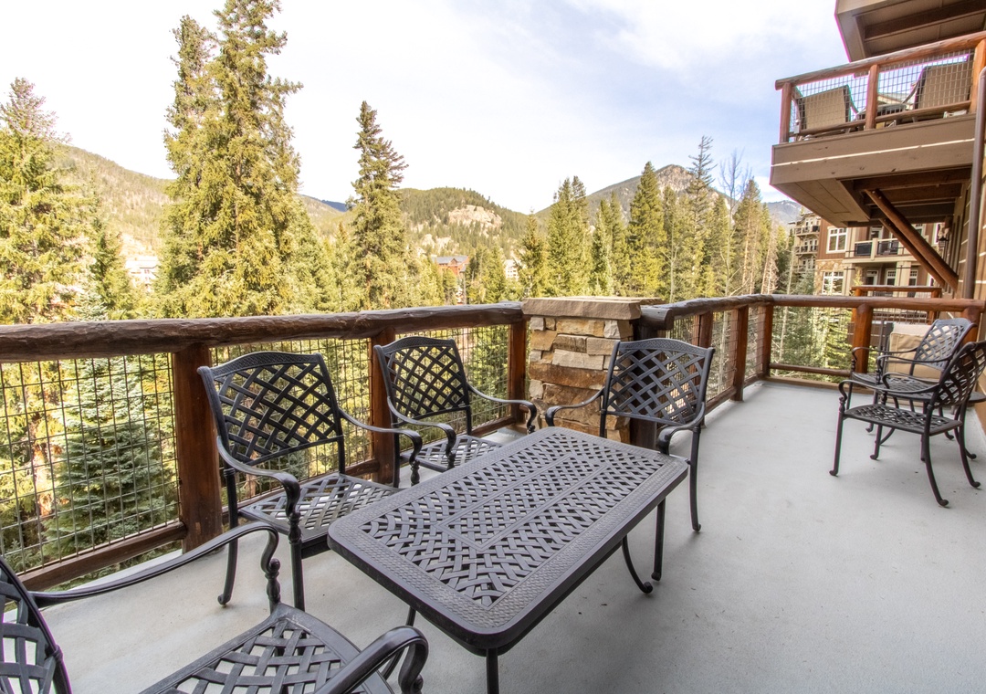 Sip your morning coffee on this spacious balcony while soaking in stunning mountain views through towering evergreens.