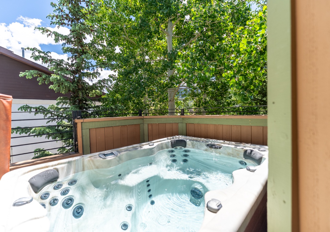 Soak your worries away in this private hot tub surrounded by lush greenery and peaceful neighborhood views.