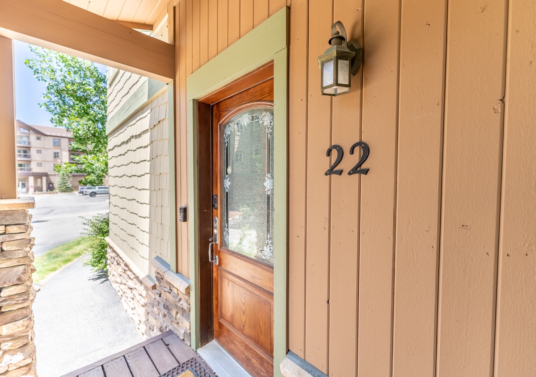 Charming entrance to unit 22 with decorative glass door and welcoming lantern lighting.