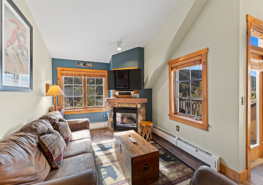Sink into plush leather seating by your crackling fireplace while mountain views frame your cozy retreat.