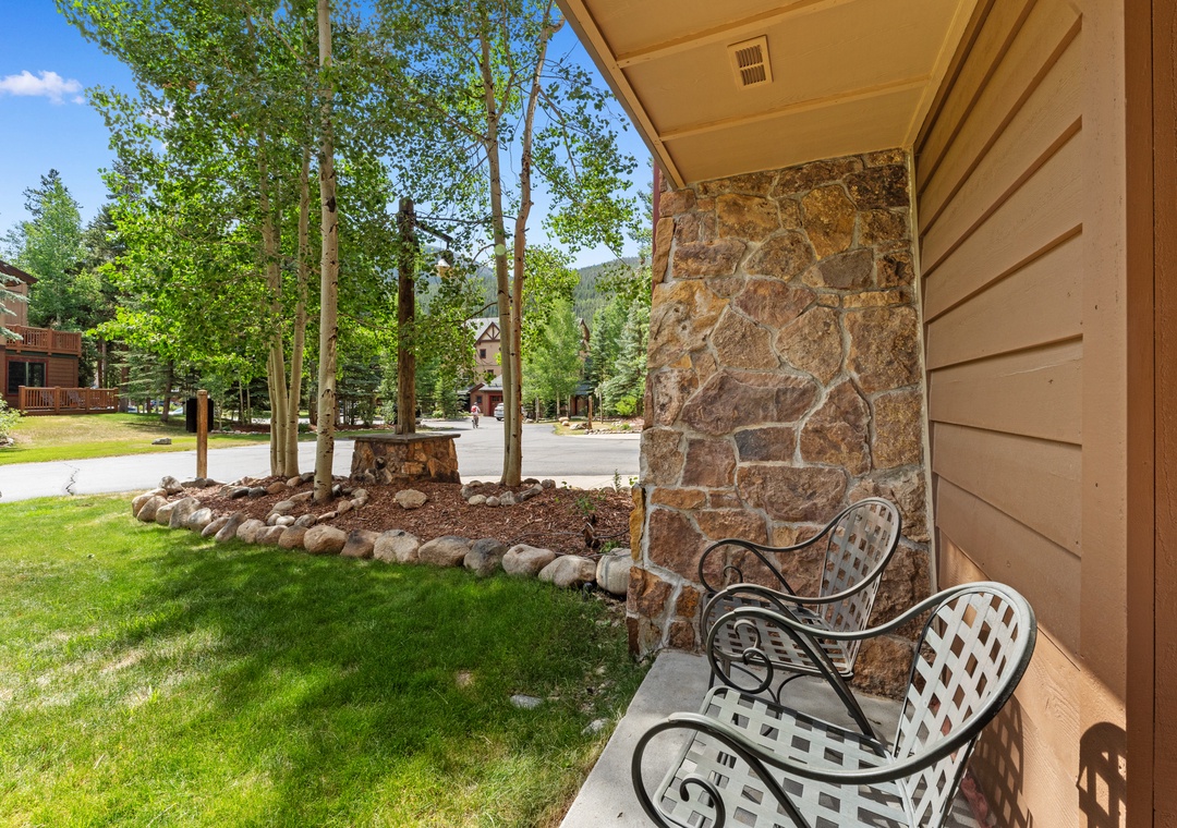 Relax on your private patio with charming chairs overlooking lush landscaping and mature trees in this peaceful mountain setting.