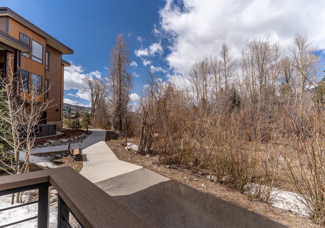 Modern mountain property surrounded by natural landscape and walking paths in a serene seasonal setting.