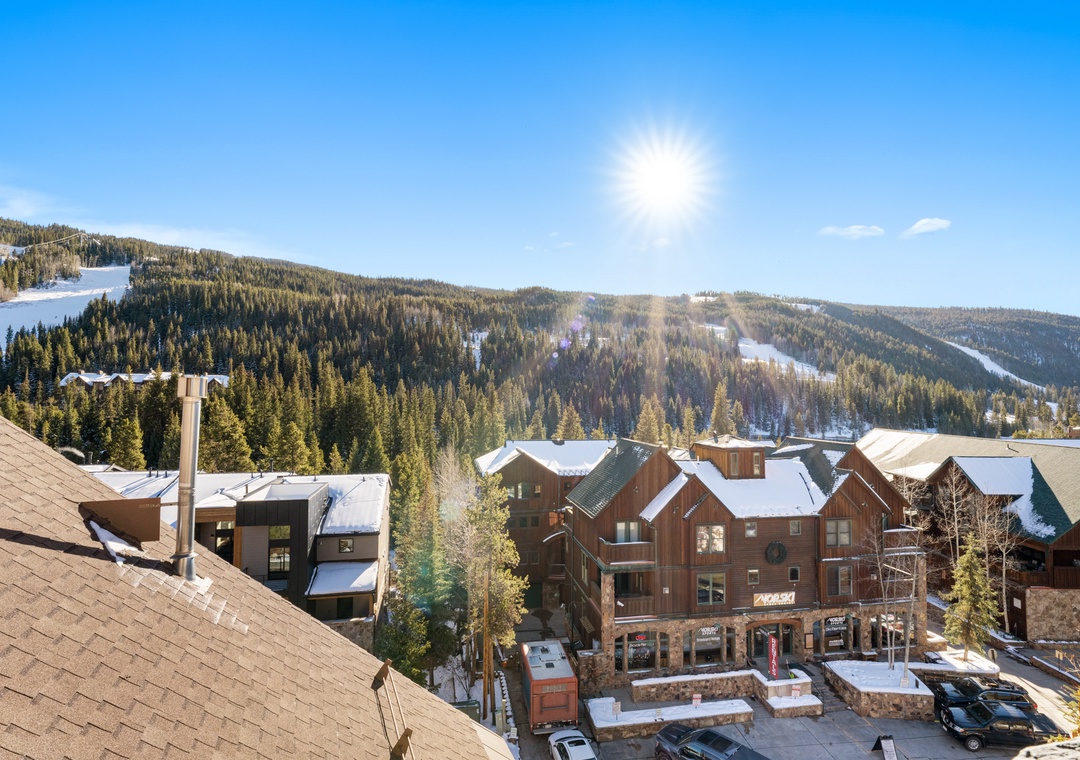 Stunning mountain village setting with snow-covered ski slopes and alpine architecture creating the perfect winter retreat backdrop.