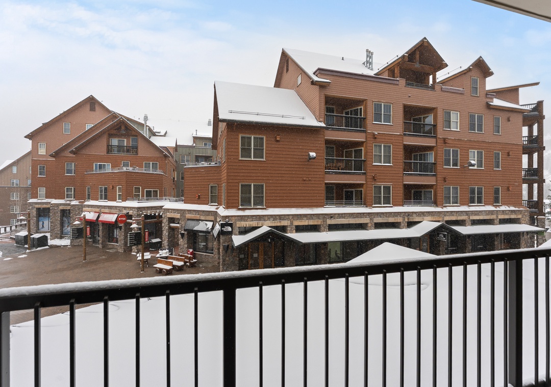 The property sits in a mountain village setting with ski-in/ski-out access, surrounded by alpine lodge-style buildings and winter scenery.