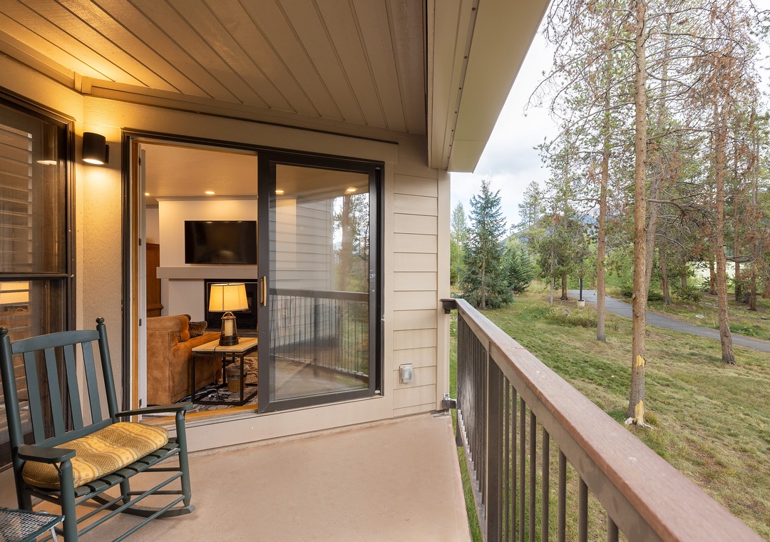 Unwind on your private balcony with forest views, where evening light filters through trees as you rock gently in your chair.