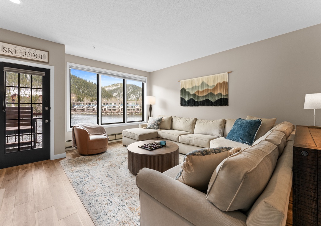 Sink into plush seating and take in stunning mountain and waterfront views through expansive windows in your cozy ski lodge retreat.