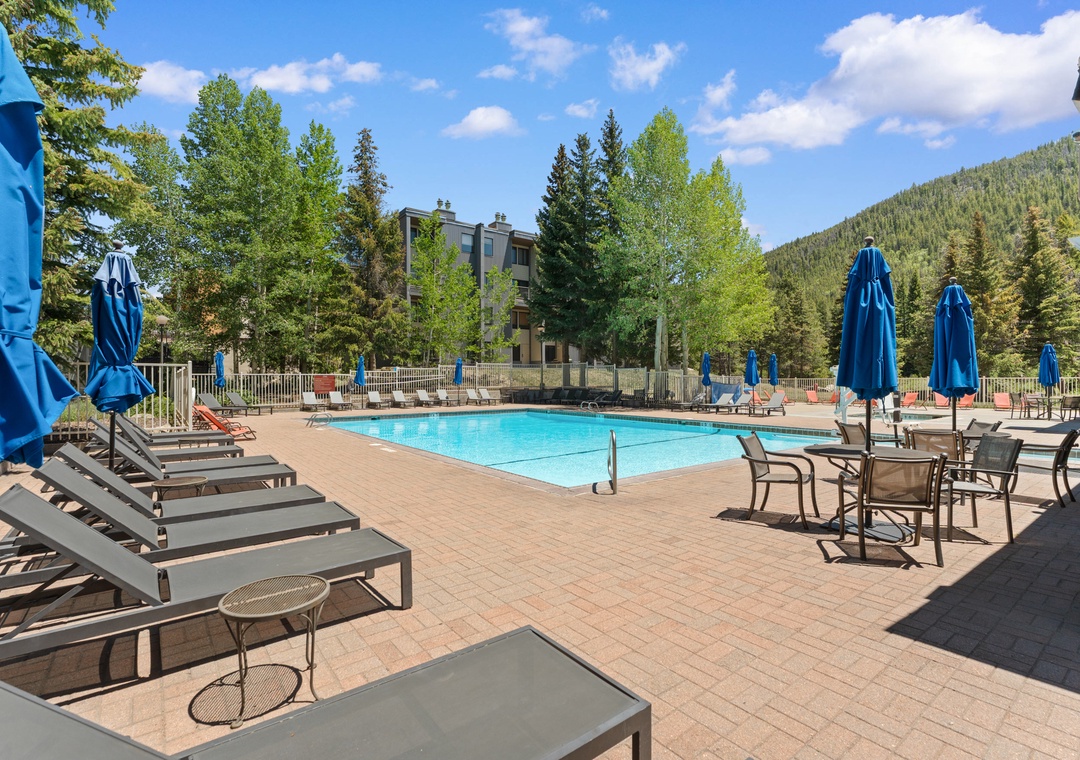 This sparkling outdoor pool offers stunning mountain views, comfortable lounge chairs, and shaded umbrella seating—perfect for unwinding after exploring the surrounding natural beauty.