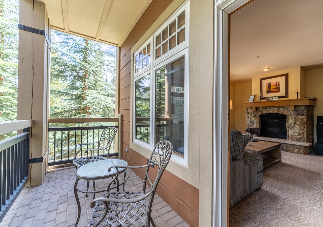 Step onto your private balcony with forest views, then retreat inside to your cozy living room with stone fireplace.