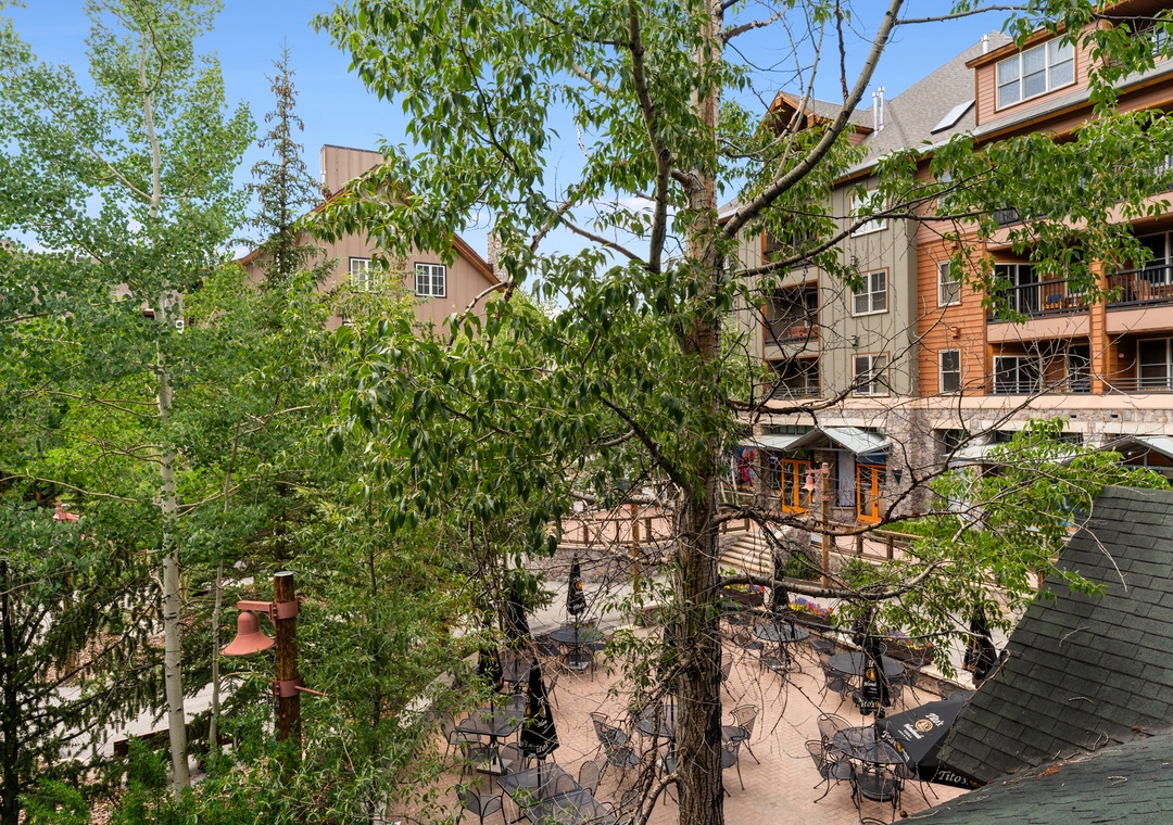 Charming tree-lined courtyard with outdoor dining creates a peaceful retreat in this welcoming neighborhood setting.