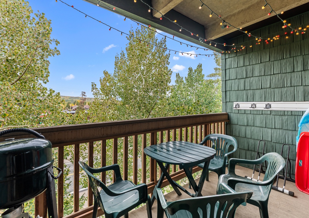 Step out onto your private balcony and breathe in the fresh mountain air. String lights above create a cozy glow as you gather around the outdoor table, perfect for morning coffee or evening relaxation under the trees.