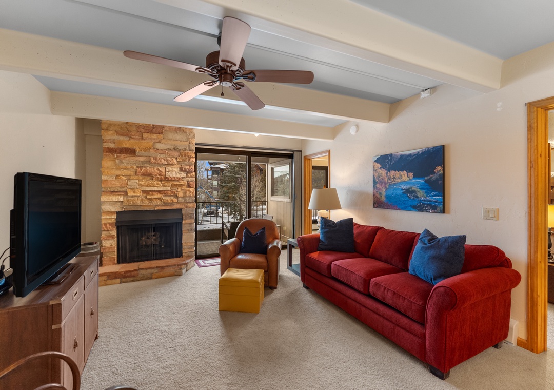 Sink into the plush red sofa and unwind by your crackling fireplace while mountain views frame your perfect getaway.