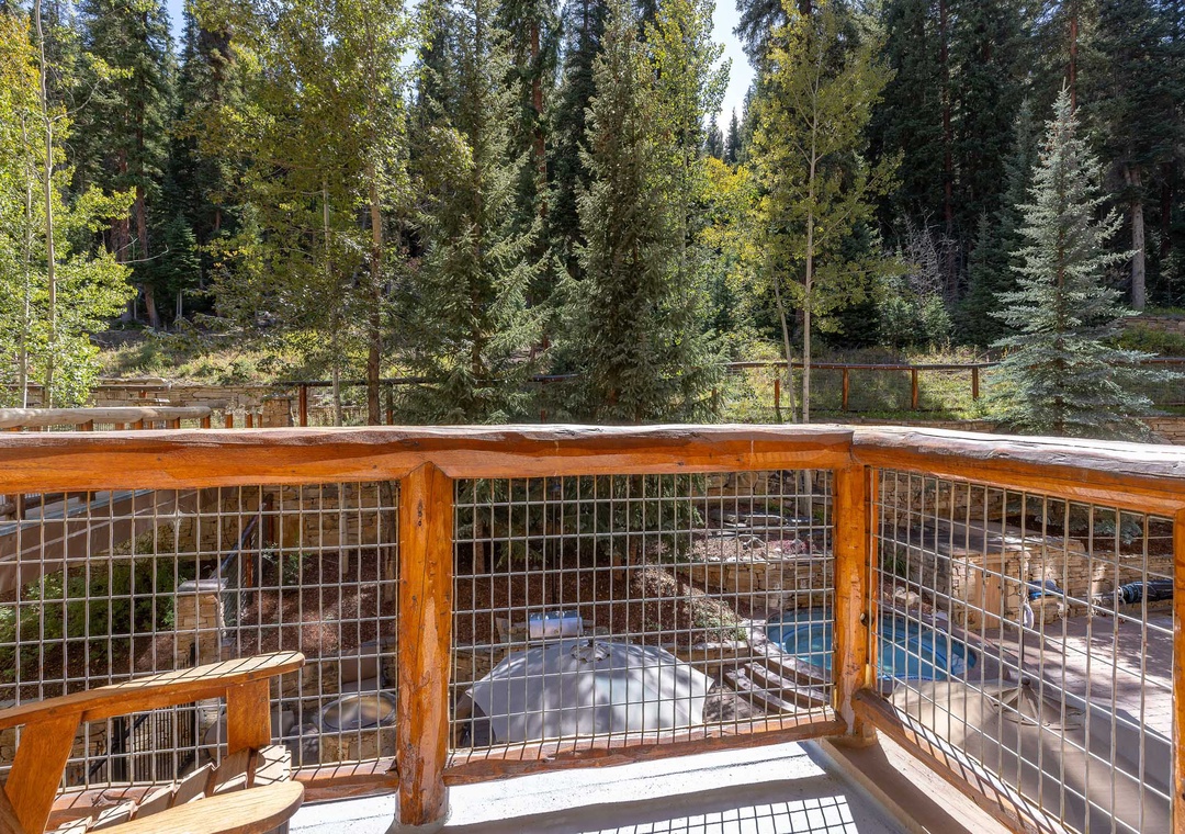 Step onto your private balcony and breathe in the fresh mountain air while overlooking the sparkling pool nestled among towering pines.