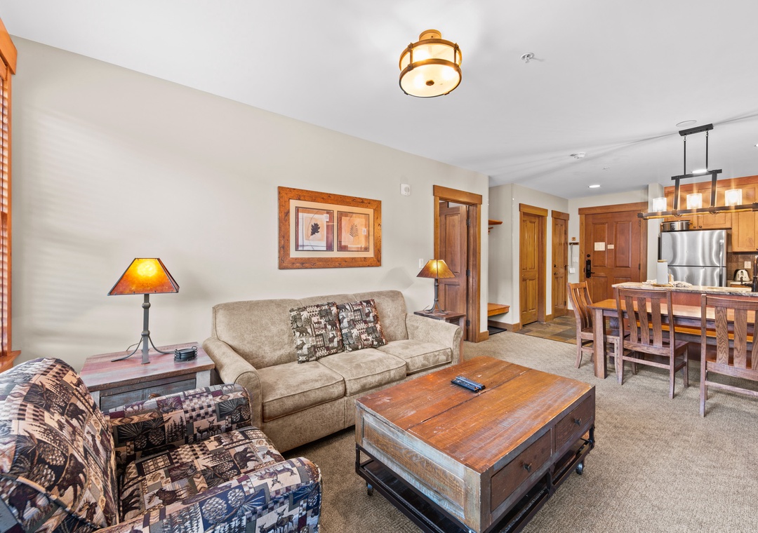 Relax in your spacious living room with rustic wood accents and cozy furnishings that seamlessly connect to your fully-equipped kitchen.