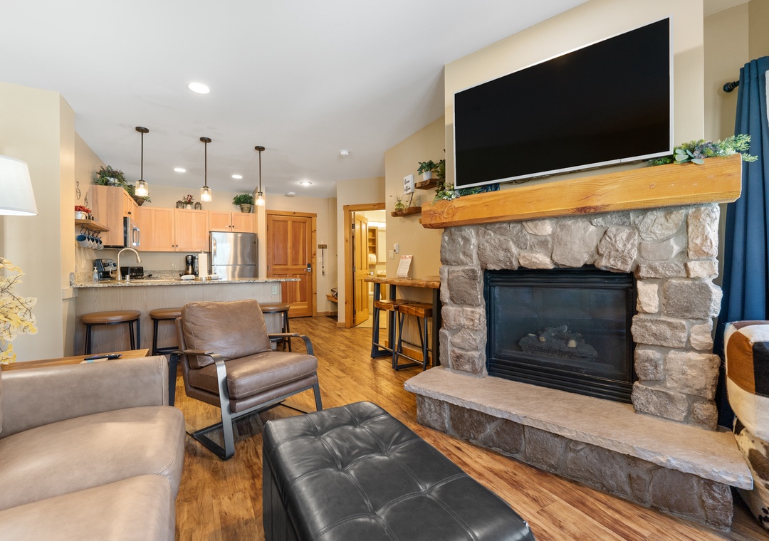 Relax by your cozy stone fireplace while enjoying the open-concept design connecting living room and fully equipped kitchen.