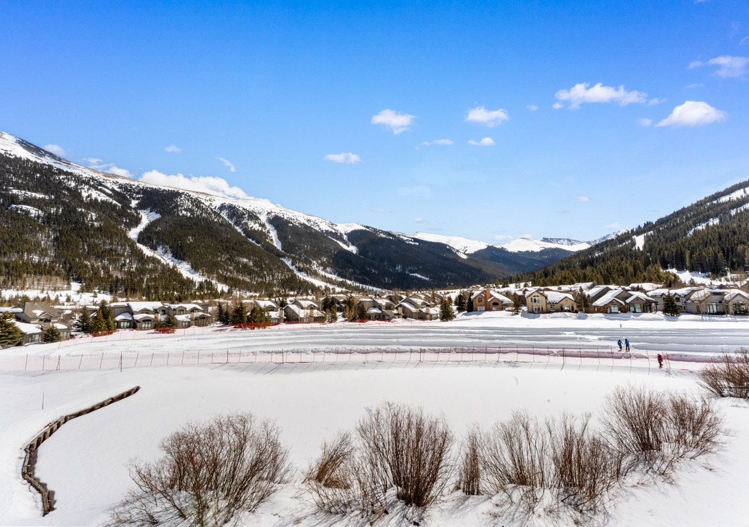 Stunning mountain valley setting surrounded by snow-capped peaks and pristine winter landscape.
