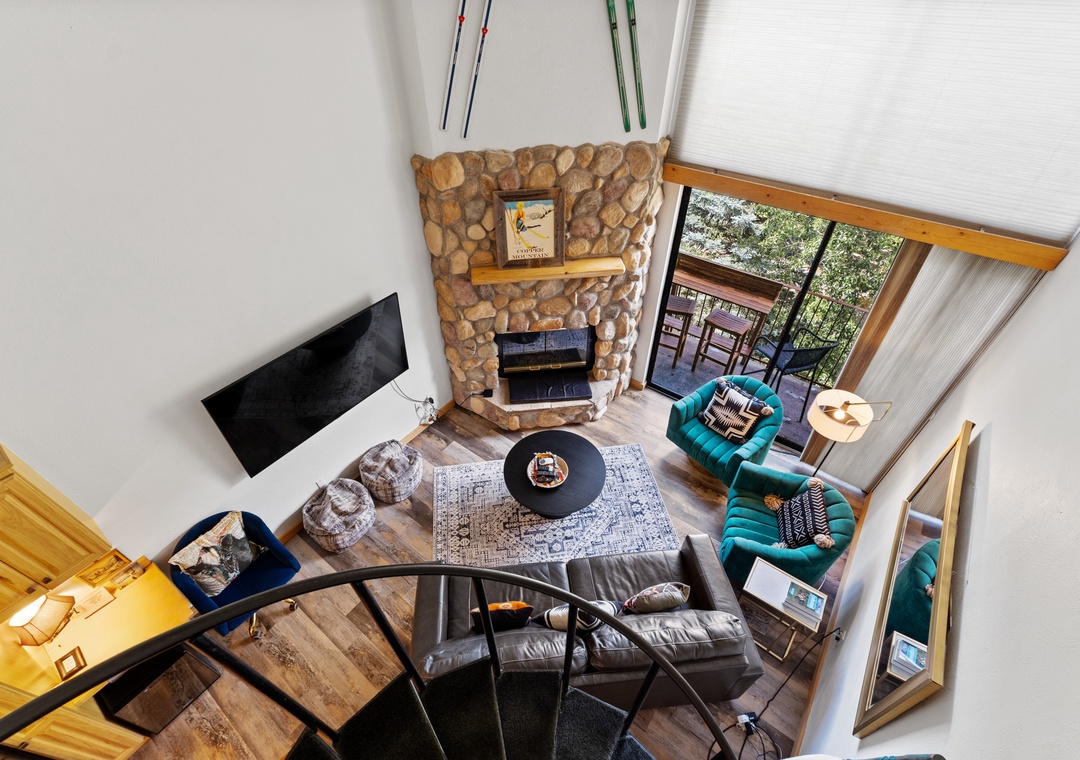Cozy up in your spacious living room with soaring ceilings, stone fireplace, and mountain views through expansive windows.