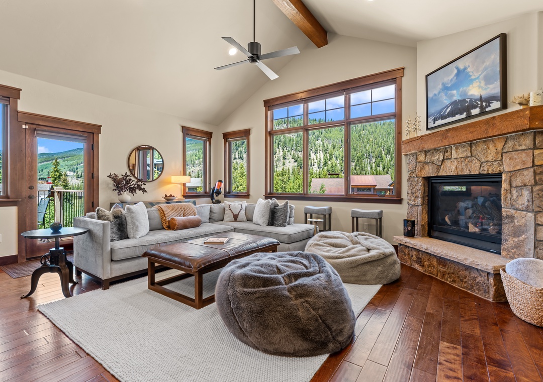 Unwind in this inviting living space where mountain views frame your relaxation. Sink into plush seating by the stone fireplace, enjoying your perfect mountain retreat.