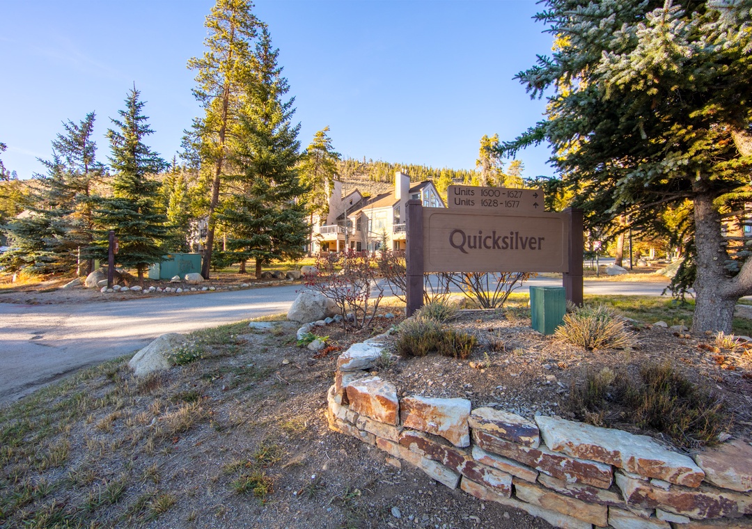 Nestled among towering evergreens, the Quicksilver property entrance welcomes visitors to this mountain retreat surrounded by natural beauty.