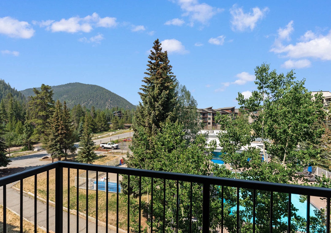 Mountain-framed setting with evergreen forests, turquoise pools below, and seasonal outdoor activities nearby.