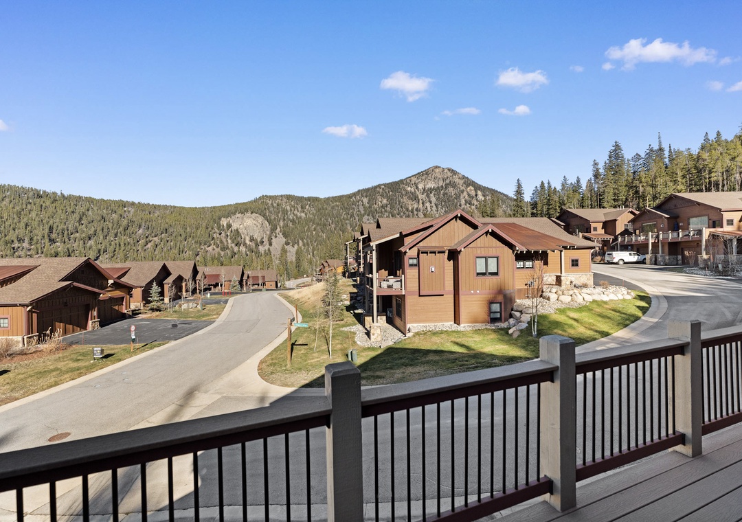 Mountain resort community nestled among forested peaks with winding roads connecting charming wooden buildings.