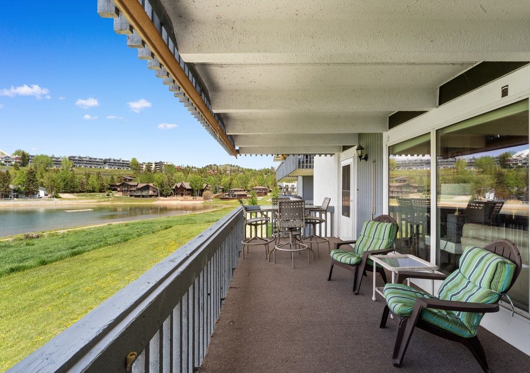 Relax on your private lakefront balcony with comfortable seating and dining space, overlooking peaceful waters and green lawns.
