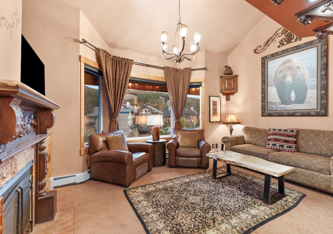 Cozy up in this mountain lodge-style living room where warm leather chairs and rustic decor create your perfect retreat.