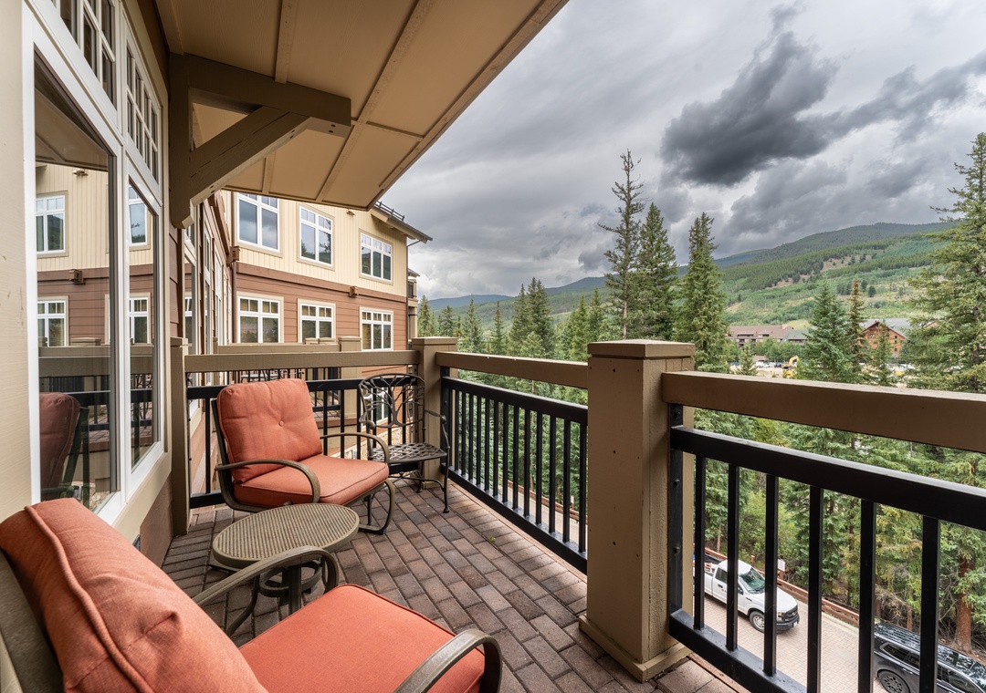 Relax on your private balcony with plush seating while taking in stunning mountain views and forest scenery stretching to the horizon.