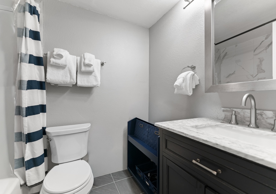 Your private bathroom features a sleek marble vanity, fresh towels, and a spacious shower with a glass enclosure—perfect for unwinding after a day of adventure.