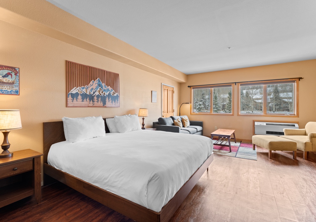 Sink into plush bedding and wake to stunning mountain views through your windows. This spacious retreat blends warm wood tones with cozy seating areas, creating your perfect ski-country escape.