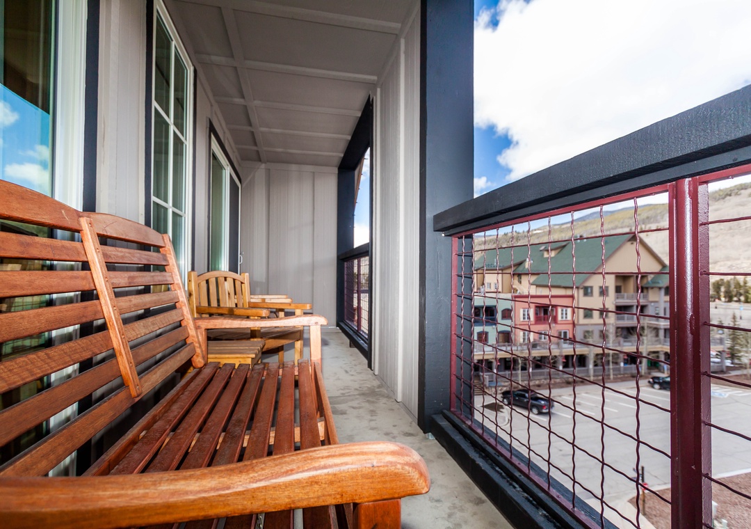 Unwind on your private balcony with warm wooden seating, where mountain views and fresh air create the perfect retreat.
