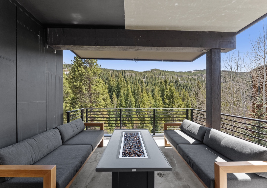 Unwind on your private terrace with a modern fire table while soaking in panoramic forest views.