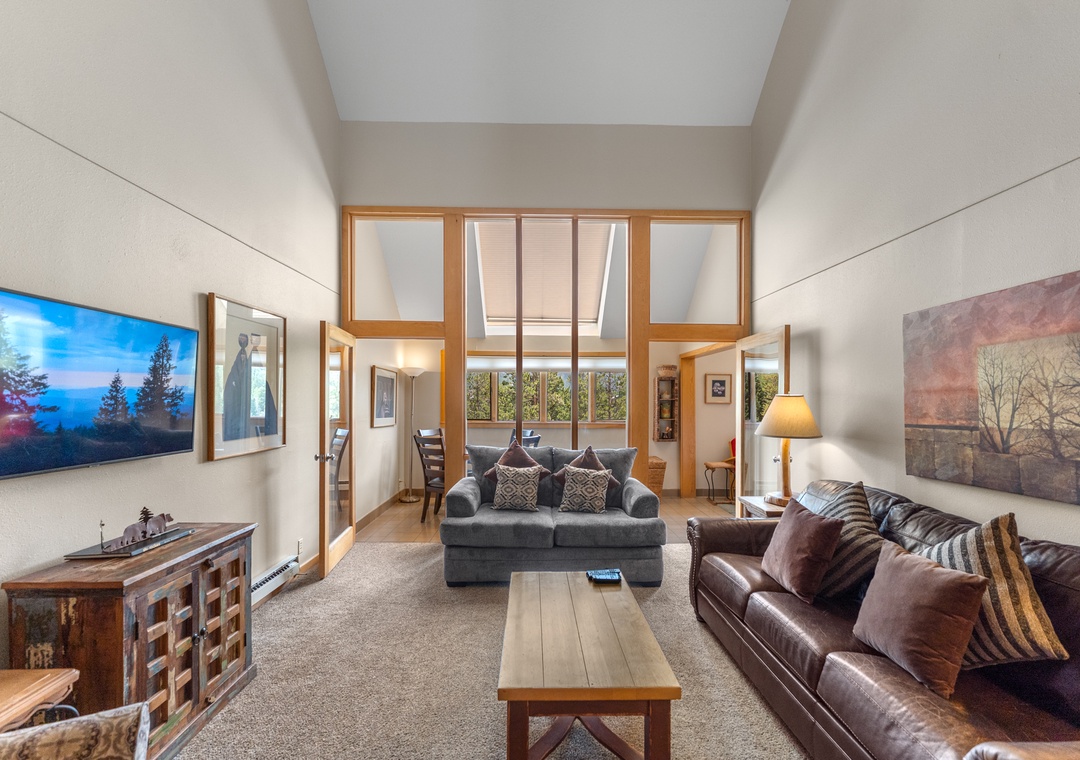 Unwind in this bright living room where plush leather sofas and soaring ceilings create your perfect mountain retreat sanctuary.