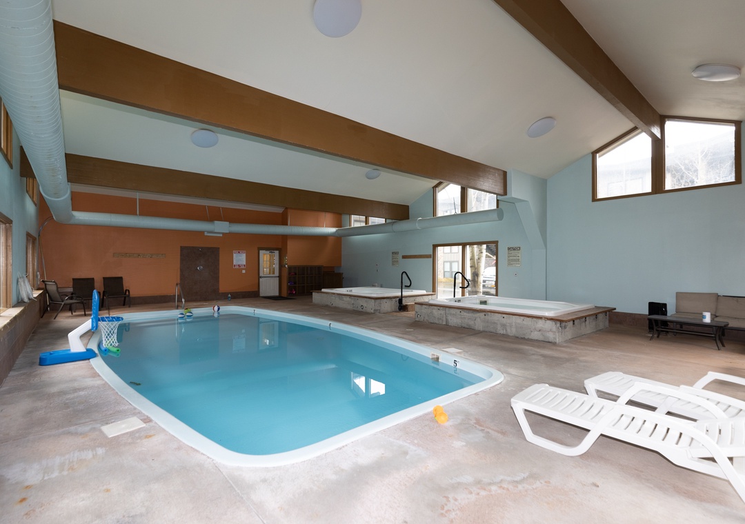 Dive into your private indoor pool with basketball hoop, surrounded by loungers and a relaxing hot tub—perfect for year-round fun.