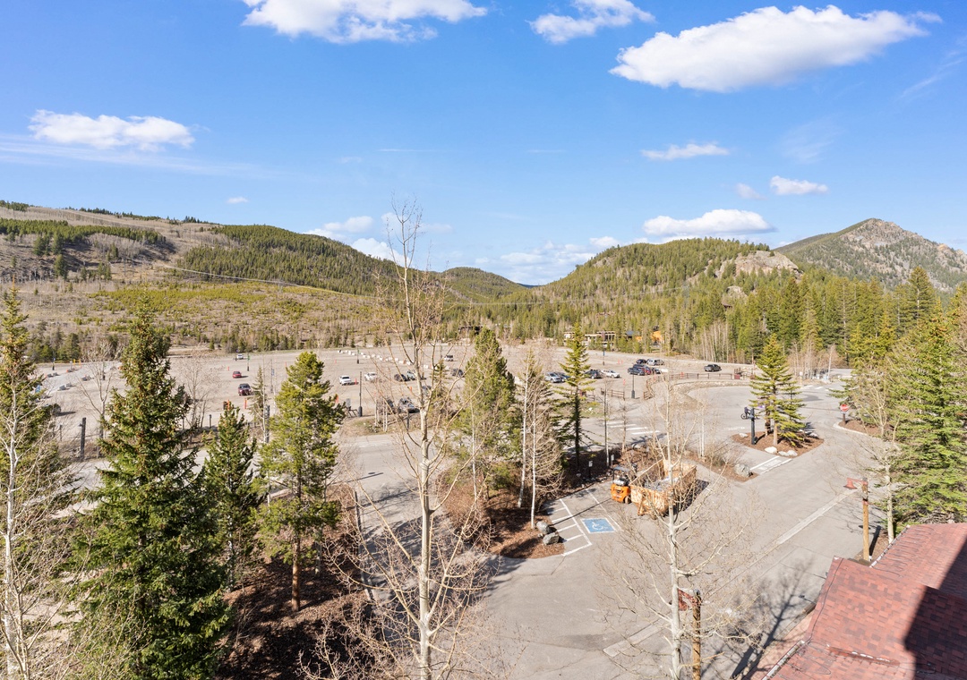 A scenic mountain valley with forested peaks and a parking area, part of the surrounding natural landscape near the property.