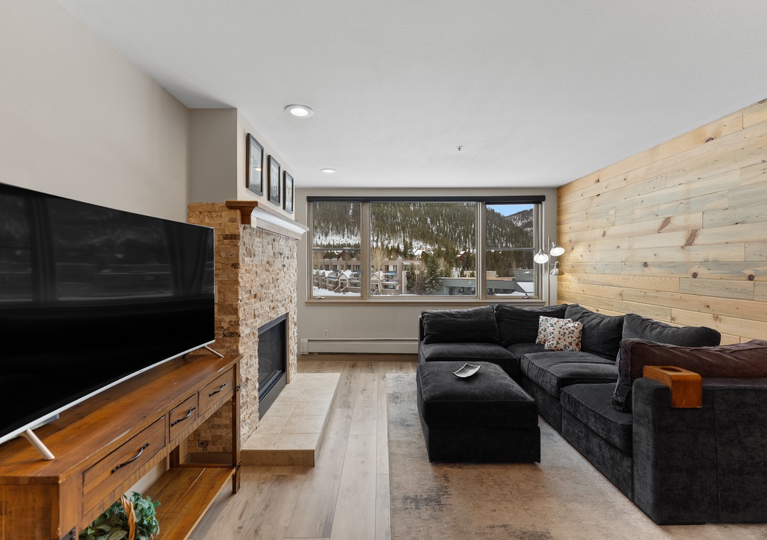 Unwind on the plush sectional while mountain views frame your cozy retreat, complete with fireplace warmth and modern comforts.