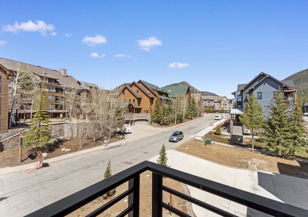 Mountain village views from your private balcony, where colorful alpine homes and forested peaks create a perfect retreat backdrop.