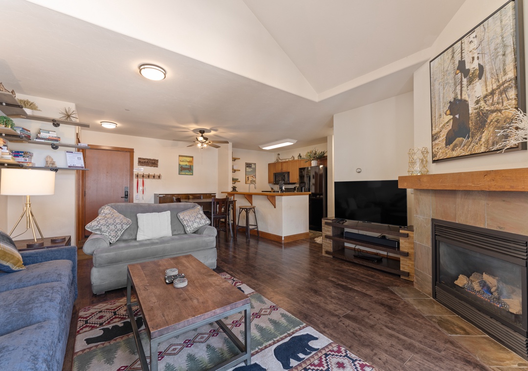 Unwind in your cozy living space with comfortable seating, warm fireplace, and open kitchen—perfect for relaxing after mountain adventures.