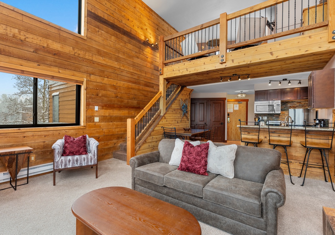 Relax in your sunlit living area with soaring ceilings and charming wood walls. The lofted space adds adventure, while the open kitchen invites you to cook and gather with loved ones.