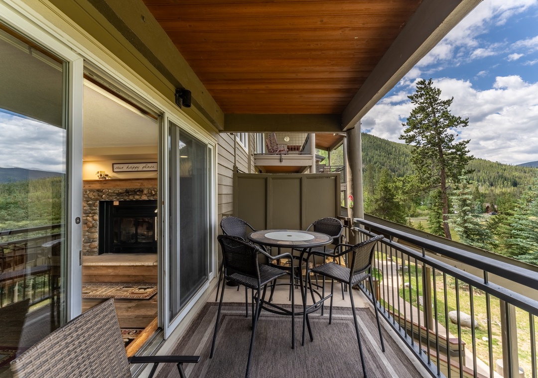 Step onto your private balcony and breathe in mountain air while enjoying forest views. The cozy fireplace glimpsed inside promises warmth after days exploring.