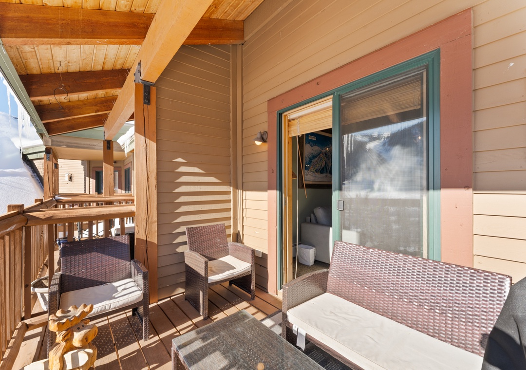 Soak up mountain sunshine on your private balcony, where comfortable seating invites morning coffee moments and peaceful alpine views.