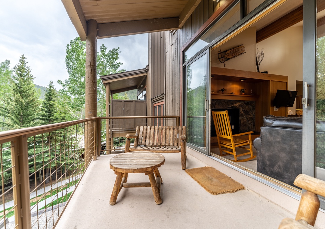 Unwind on your private balcony with mountain views, where rustic wooden furniture invites peaceful moments overlooking the forest.