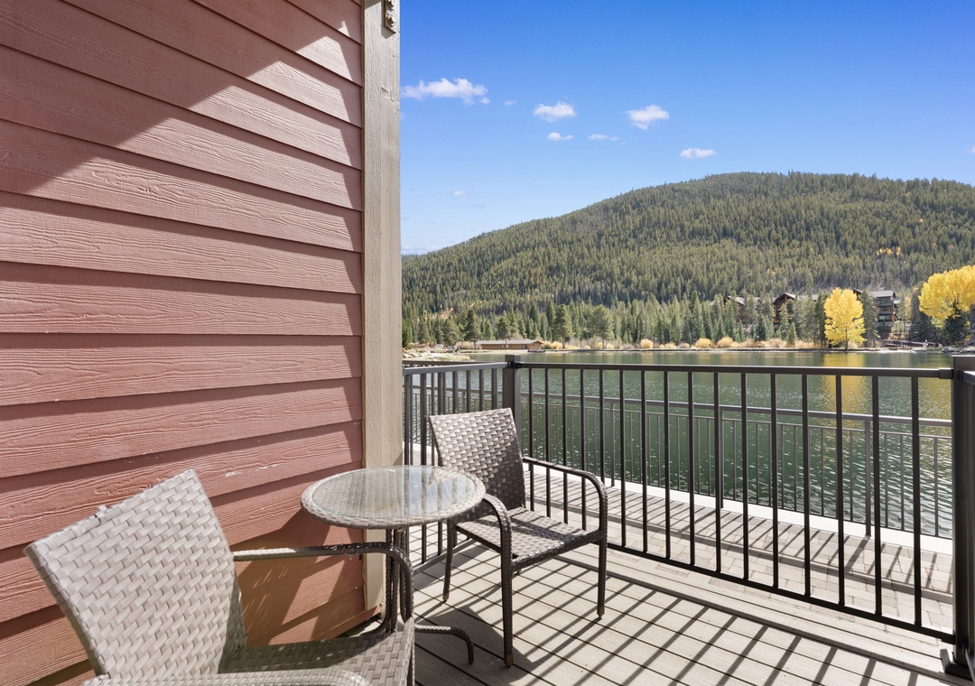 Step onto your private balcony and take in the stunning lakefront setting, where forested mountains frame the sparkling water and golden autumn trees dot the shoreline—your serene escape awaits.