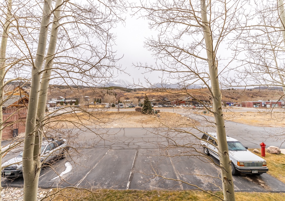 Parking area overlooking a quiet residential neighborhood with rolling hills and mountain backdrop.