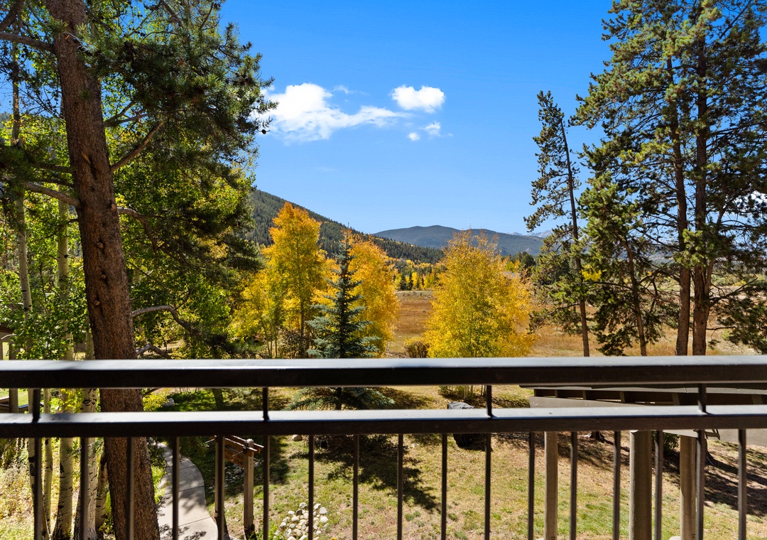Breathe in the crisp mountain air from your private balcony, where golden autumn foliage creates a stunning backdrop for your peaceful retreat.