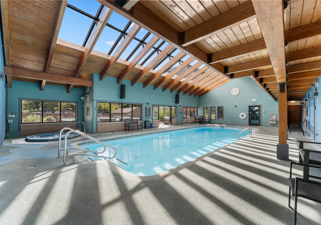 Dive into relaxation in this stunning indoor pool area with soaring wooden beams and natural light streaming through the skylights above.