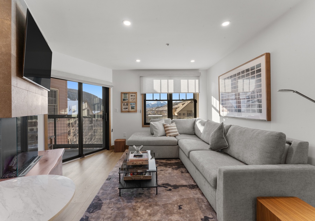 Sink into your spacious sectional sofa and enjoy mountain views through floor-to-ceiling windows in your stylish living room.