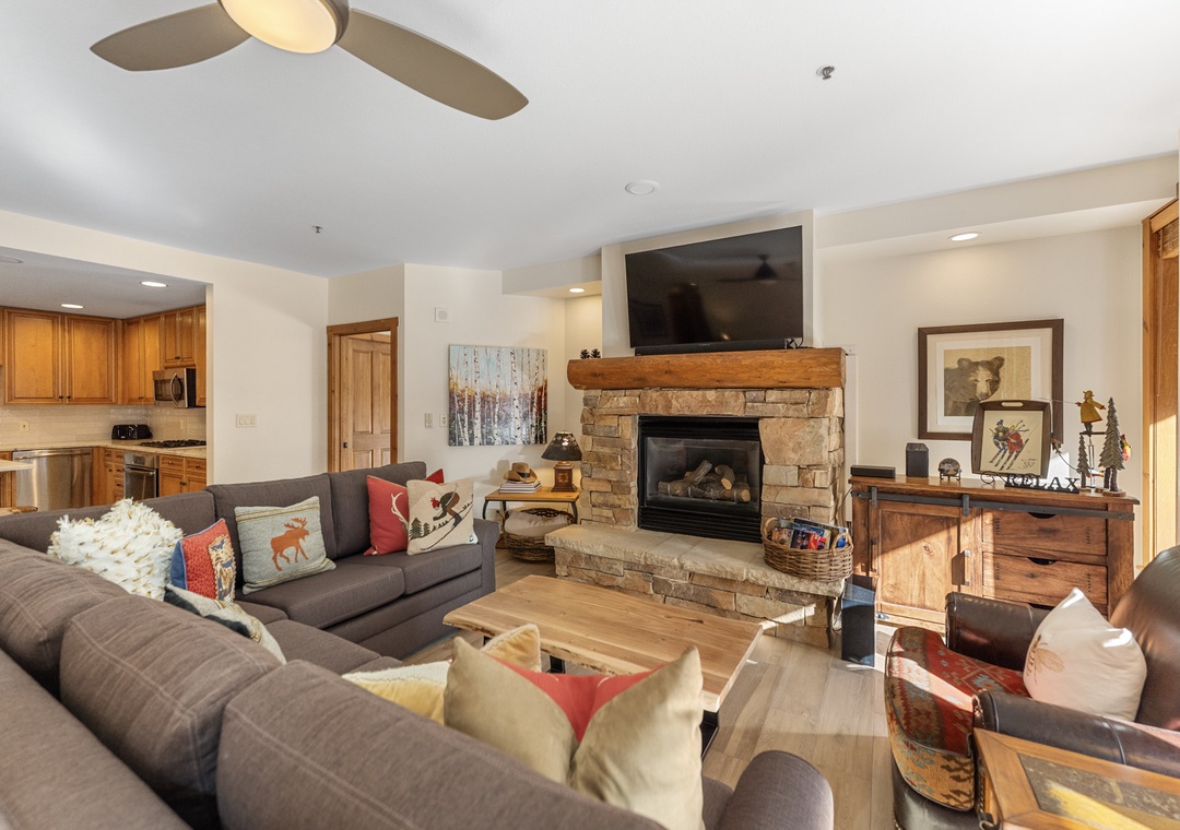 Gather around your cozy stone fireplace with comfortable seating for everyone. The open layout connects you to the fully equipped kitchen.