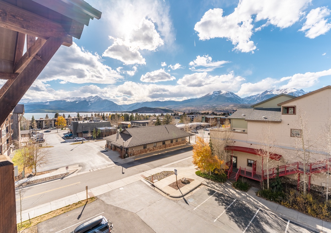 Stunning mountain panorama unfolds before this elevated balcony, showcasing snow-capped peaks and pristine lake waters in the distance.