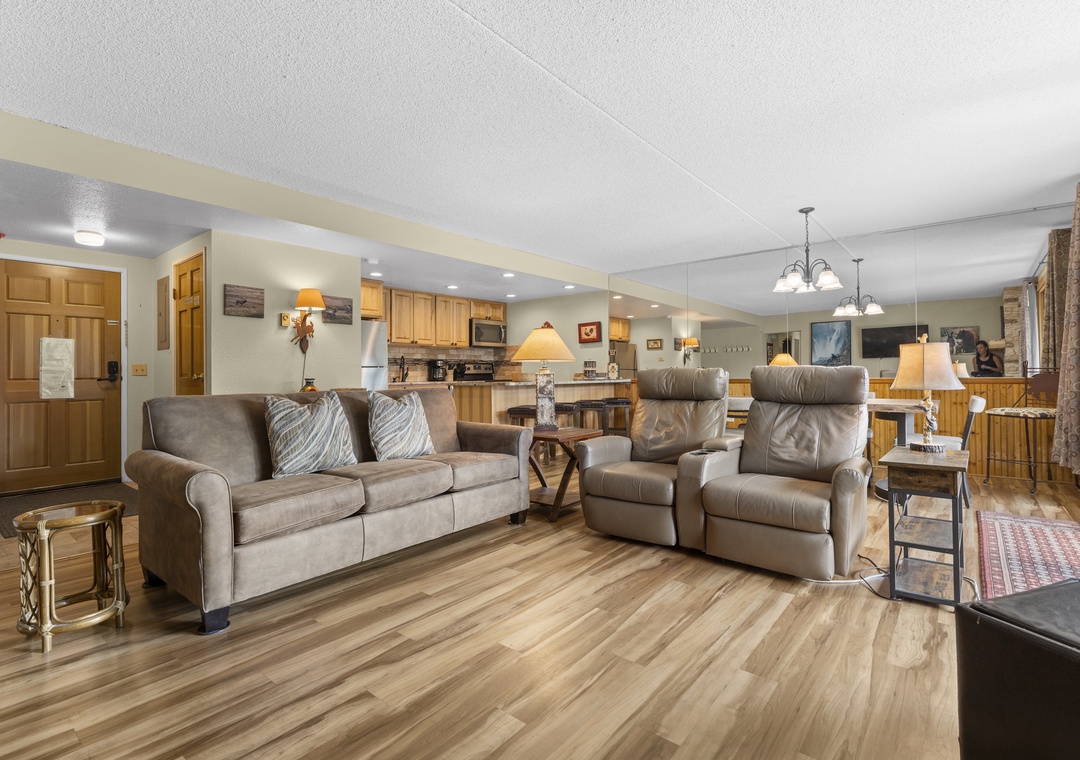 Settle into your spacious living area with plush seating, warm wood accents, and an open layout that flows into a fully equipped kitchen—perfect for gathering and making memories.